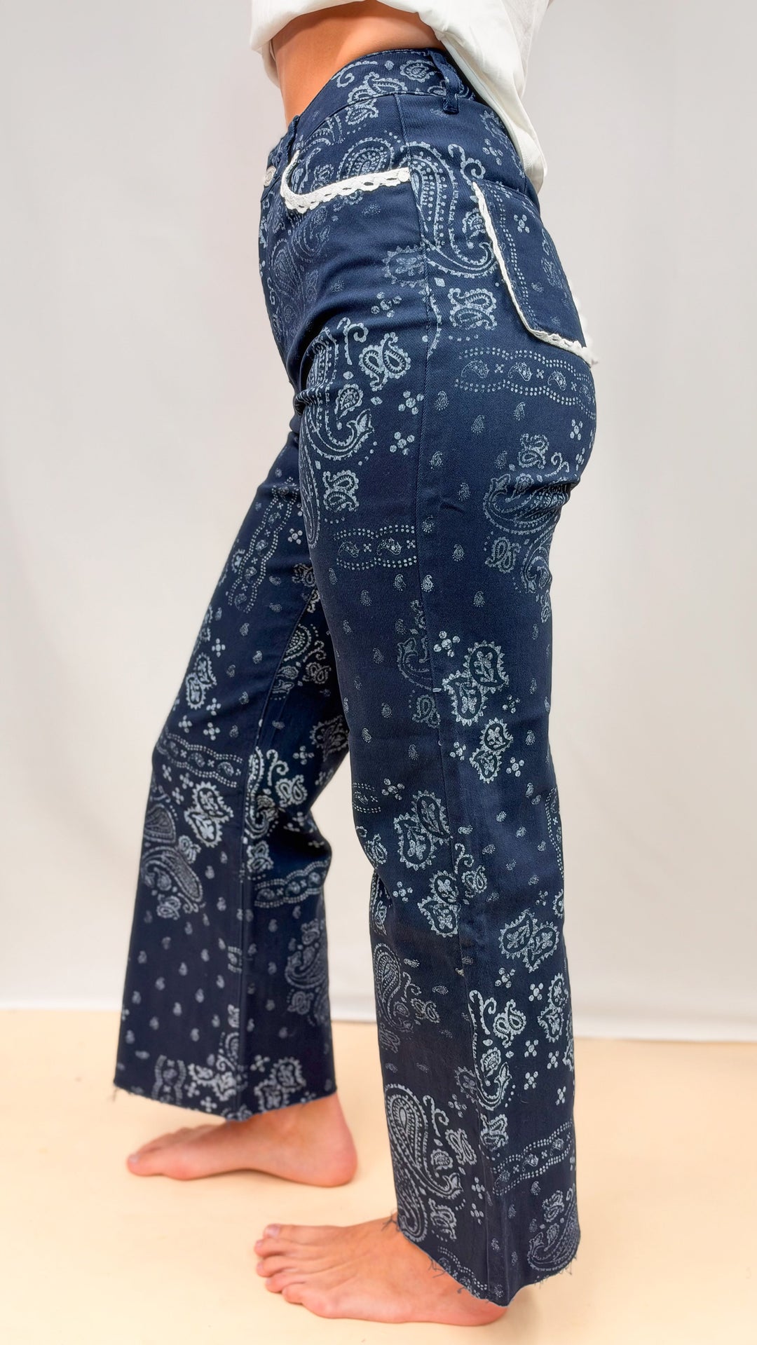 Woman wearing blue bandana print pants on plain background