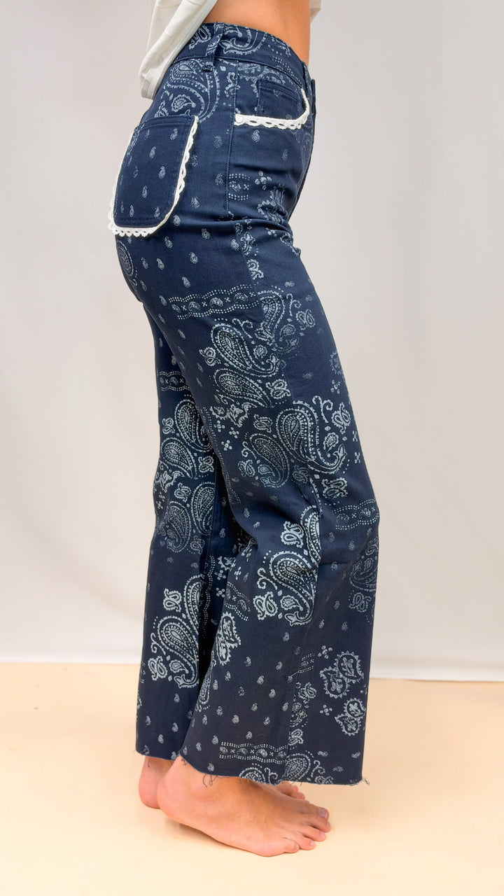 Woman wearing blue bandana print pants on plain background