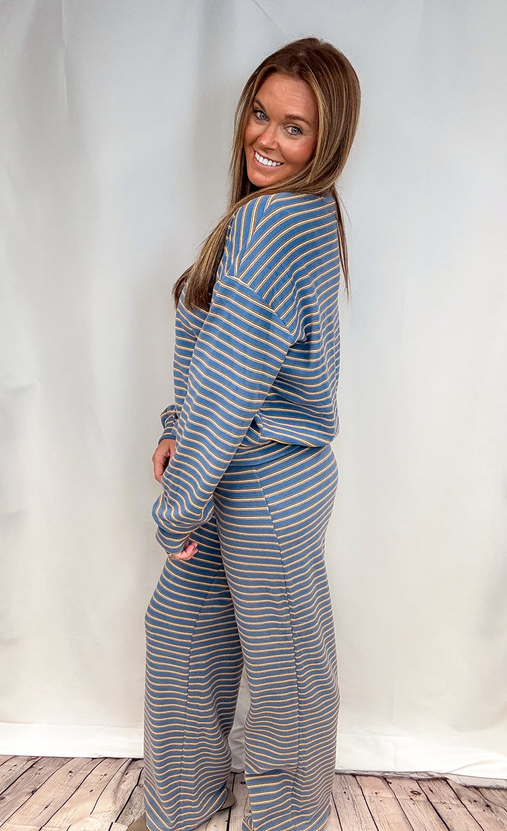 Woman wearing matching blue and yellow stripe set on plain background