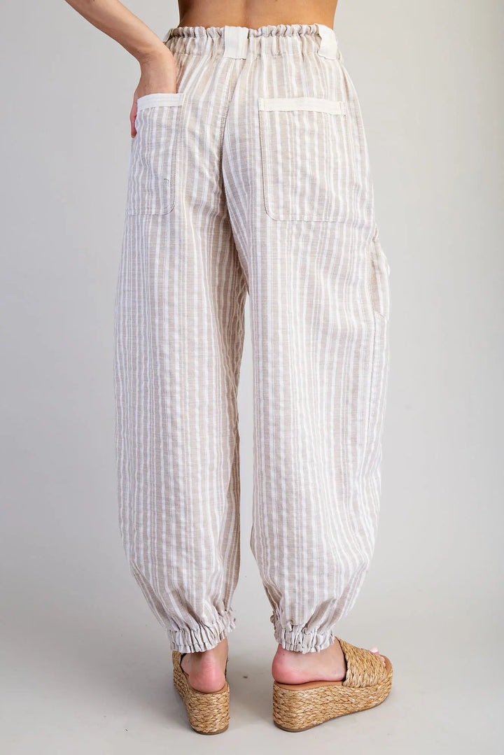 White striped pants worn by a person on a plain background