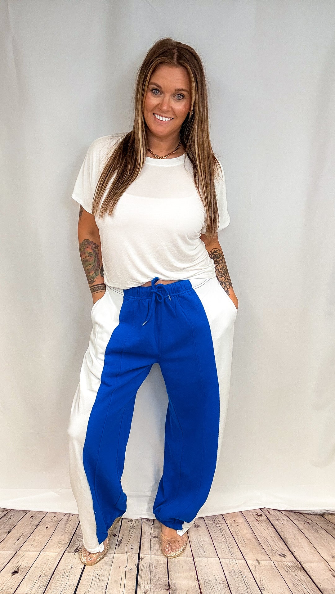 Woman wearing blue and white pants with white short sleeve shirt on white background