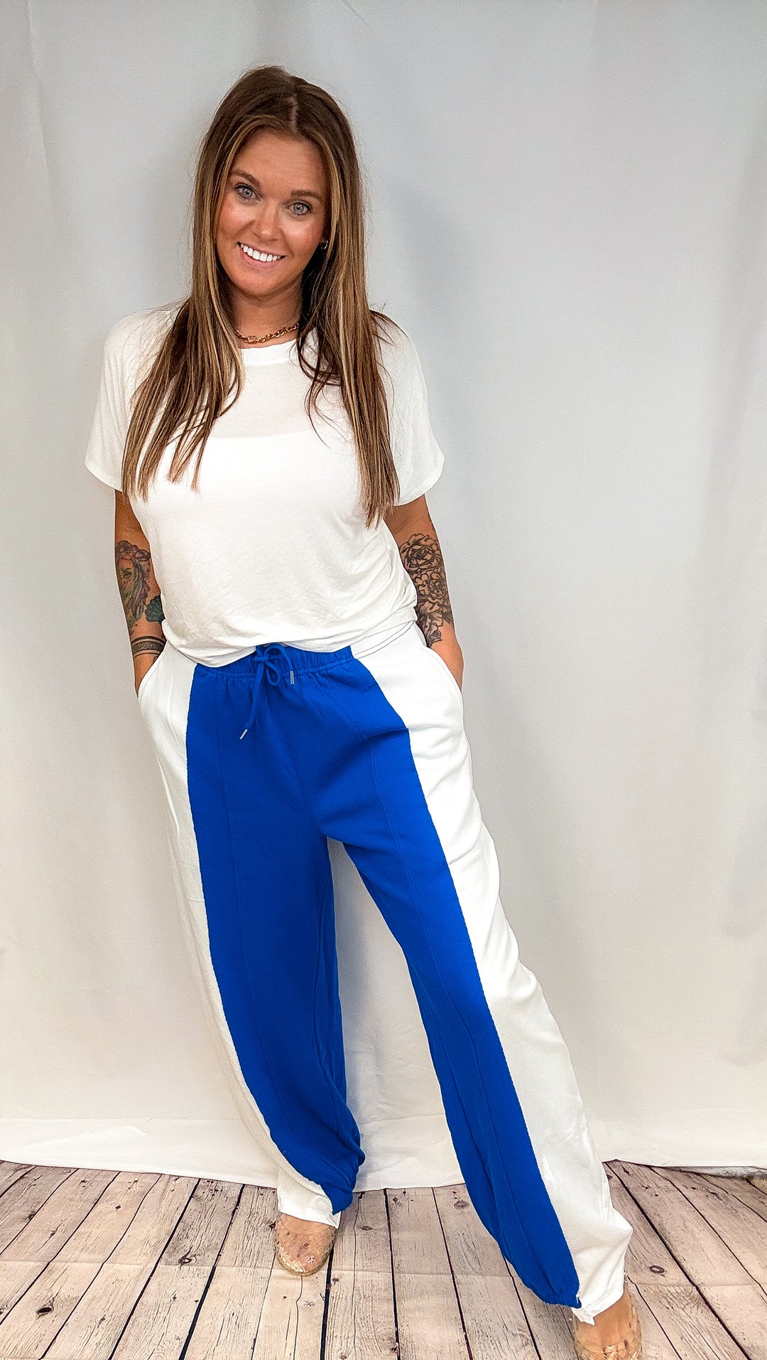 Woman wearing blue and white pants with short sleeve white shirt on white plain background