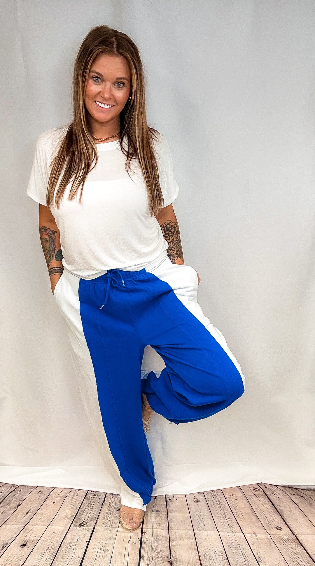 Woman wearing blue and white pants with white short sleeve top on white background
