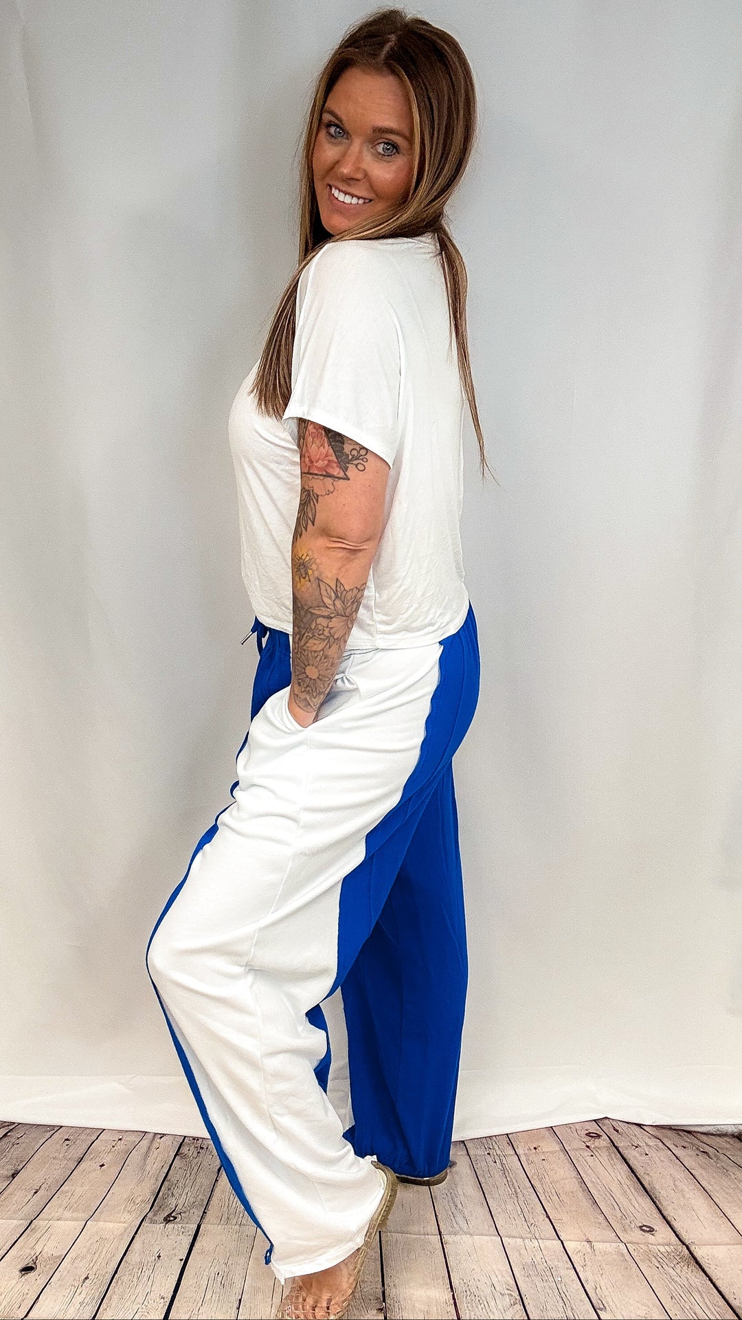 Woman wearing blue and white pants with white short sleeve shirt on white background