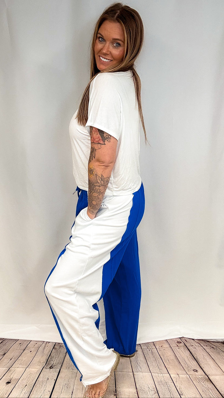 Woman wearing blue and white pants with white short sleeve shirt on white background