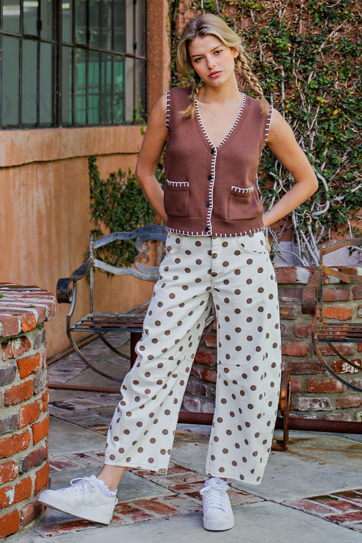 Woman wearing polka dot pants and brown vest outdoors