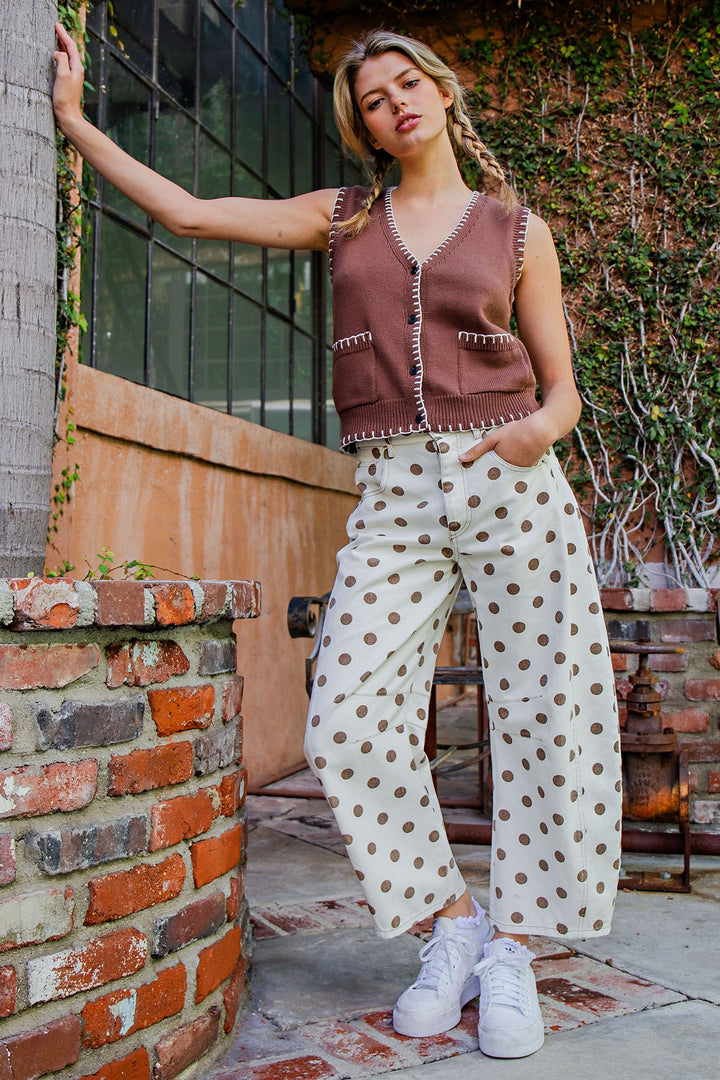 Woman wearing polka dot pants and brown vest outdoors