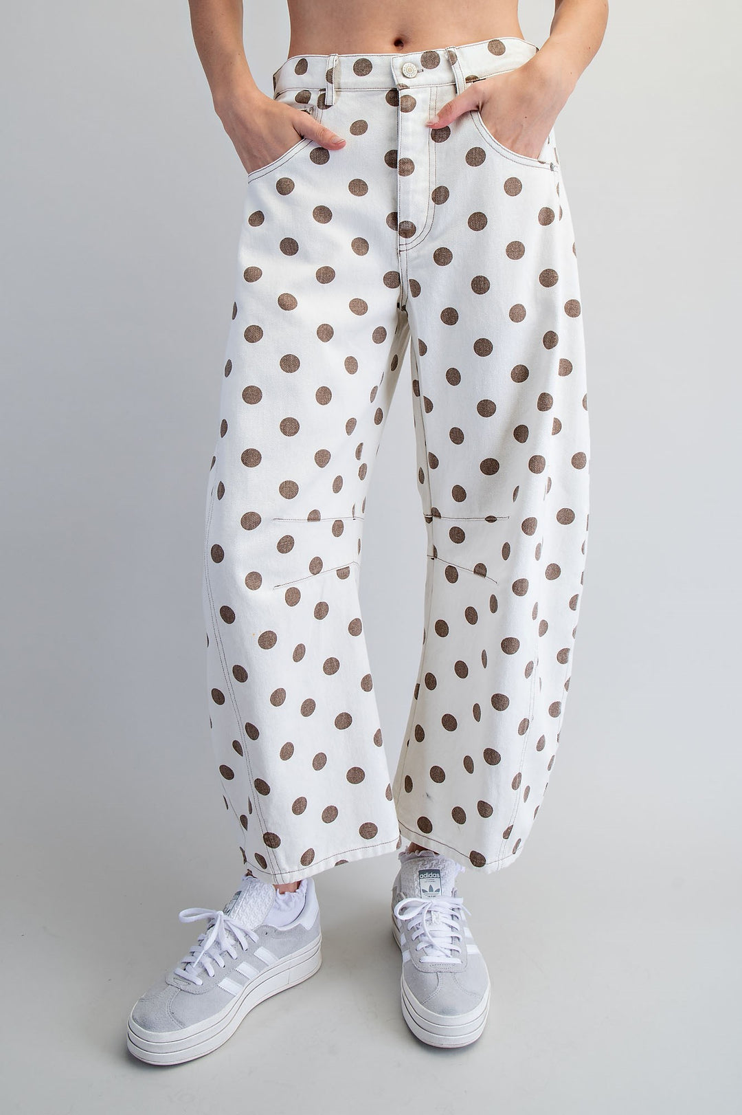Woman wearing polka dot pants on plain background
