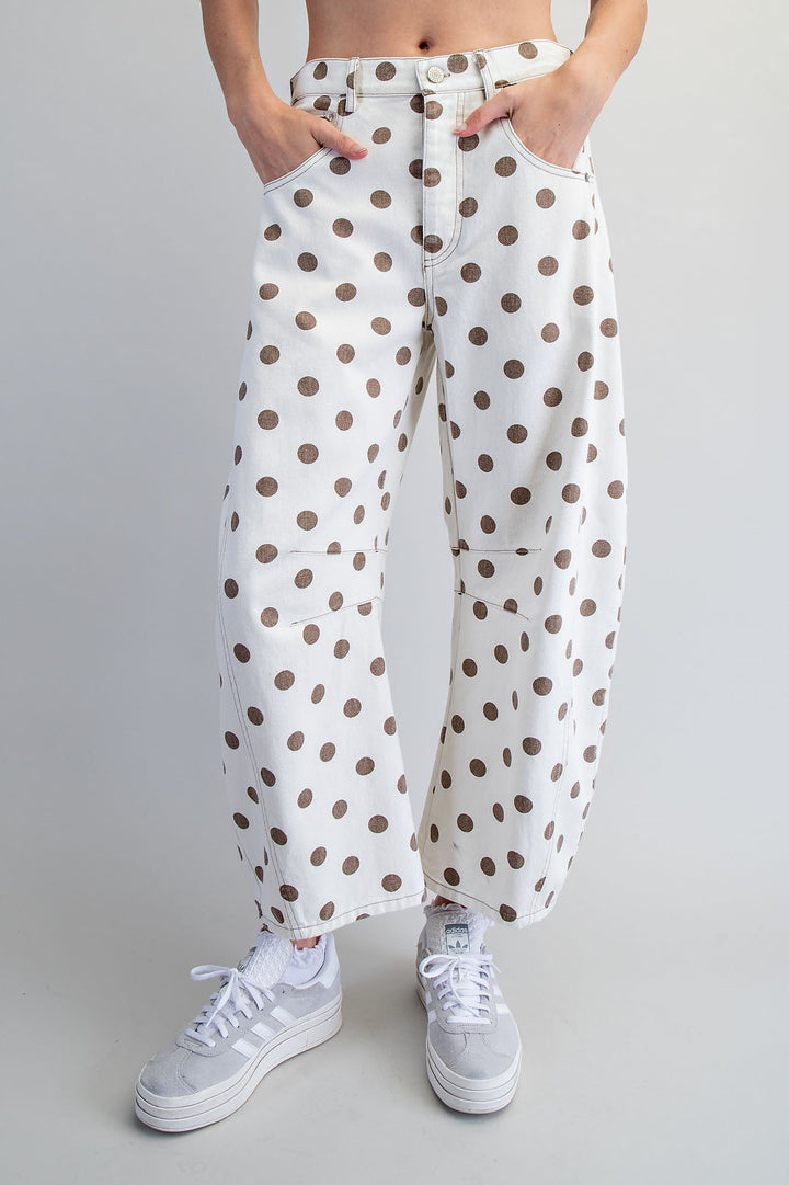 Woman wearing polka dot pants on plain background