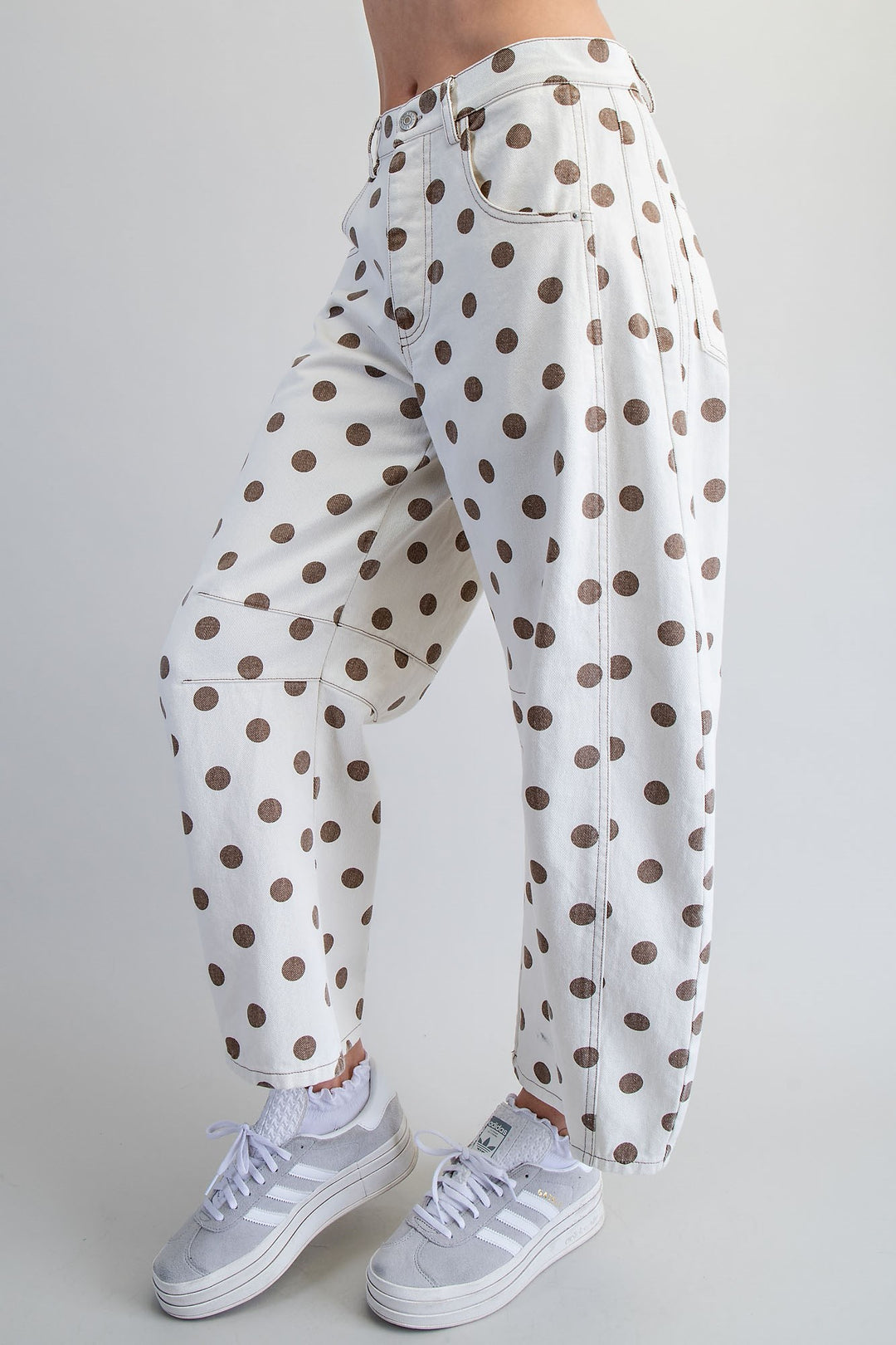 Woman wearing polka dot pants on plain background