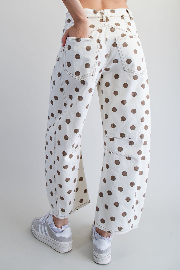 Woman wearing polka dot pants on plain background