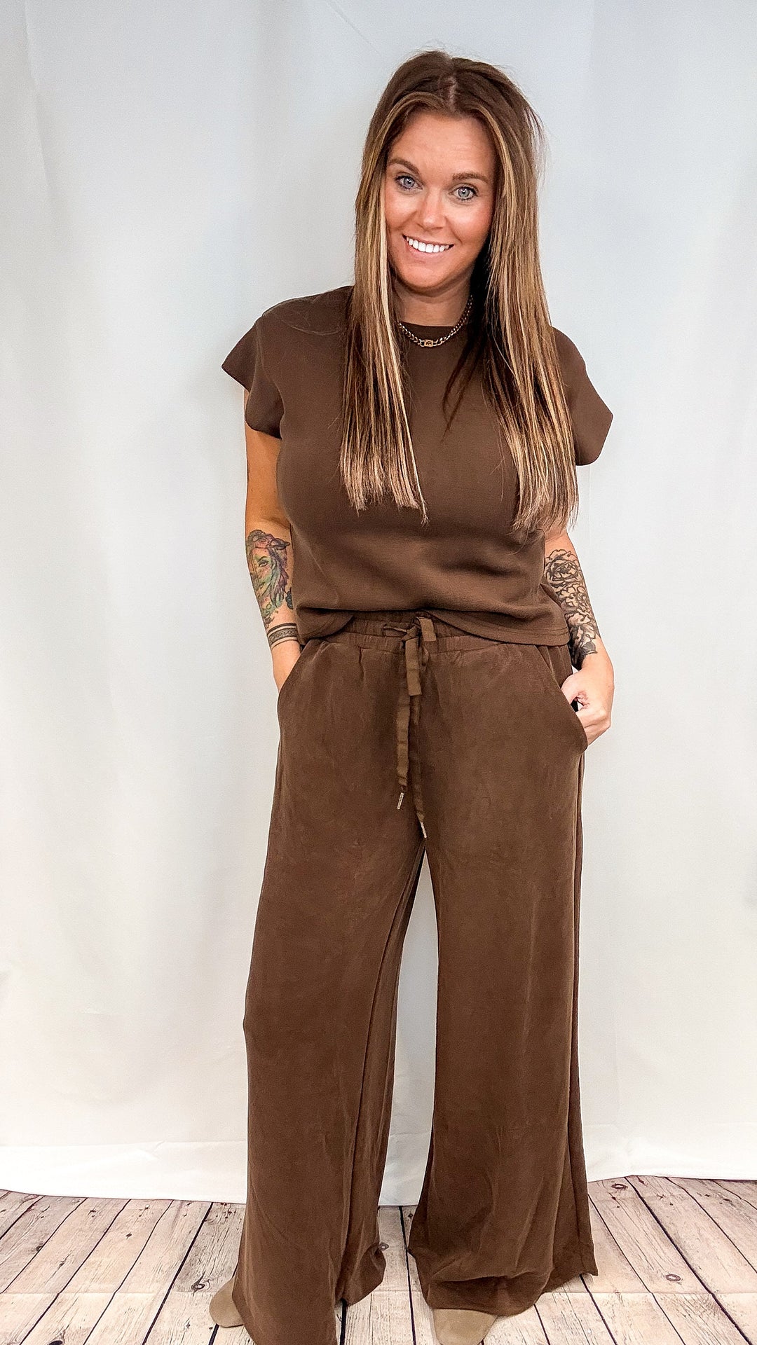 Woman wearing matching brown lounge set on white background