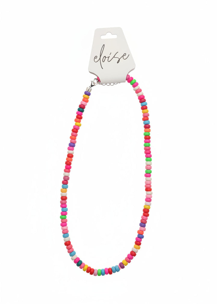 A colorful beaded necklace with small round beads in pink, blue, yellow, green, orange, and white, displayed on a white card labeled &
