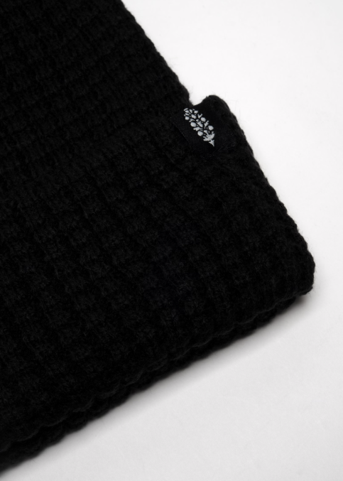 Close up of single black beanie with logo on plain background