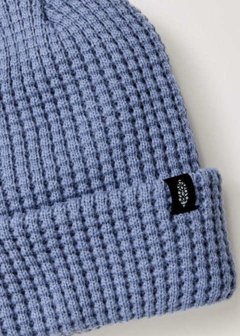 Single blue beanie with logo on plain background