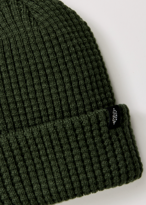 Single green beanie with logo on plain background
