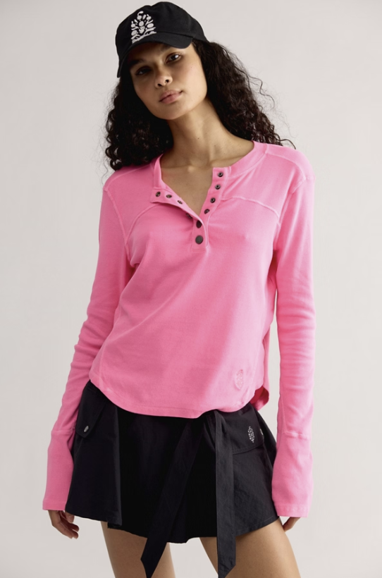 Woman wearing pink shirt and black skirt on plain background