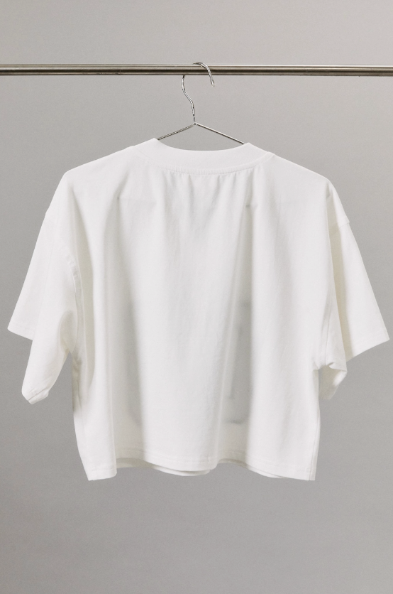 White t-shirt on a hanger against a plain background
