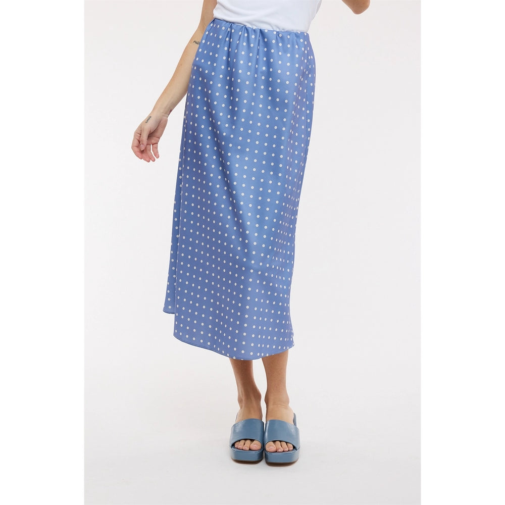 Woman wearing blue polka dot midi satin skirt on plain background