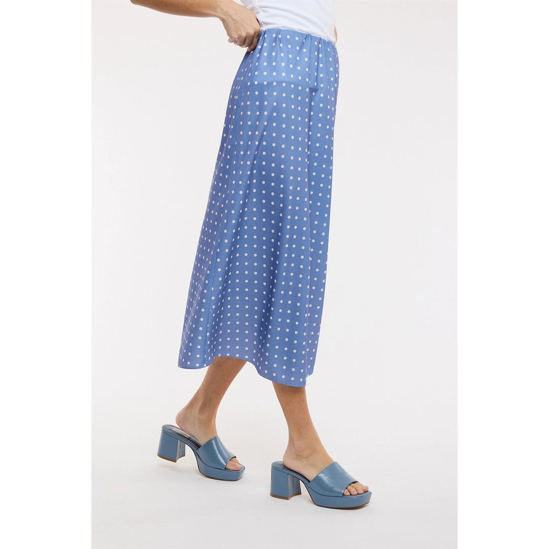 Woman wearing blue polka dot midi satin skirt on plain background