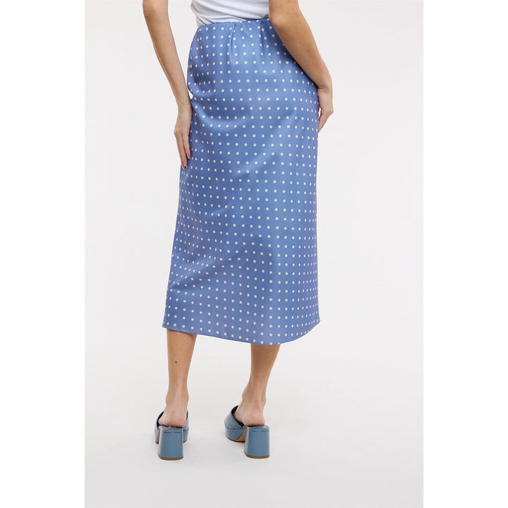 Back of woman wearing blue polka dot midi satin skirt on plain background