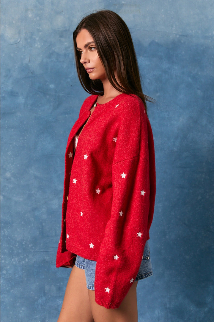 Woman wearing red cardigan with white stars on blue background