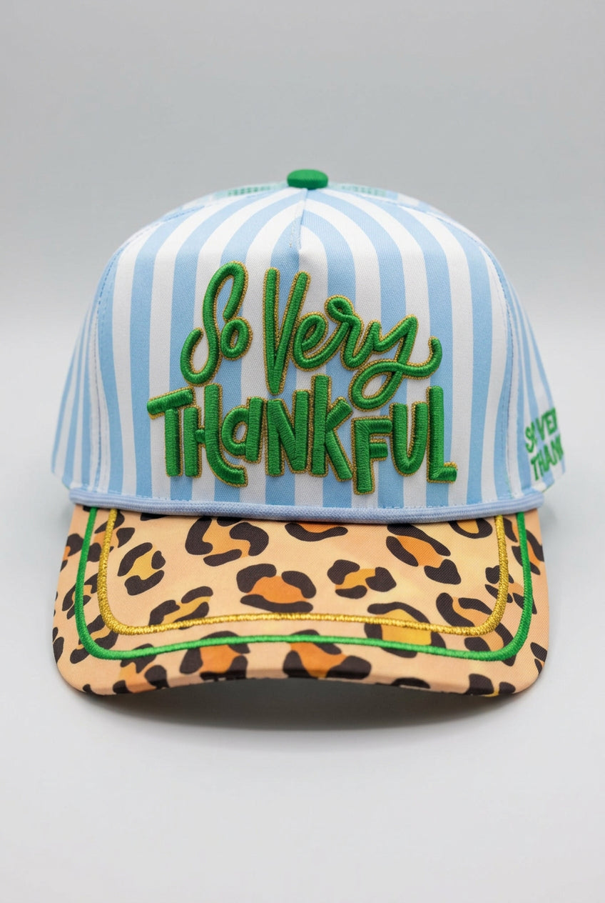 Trucker hat with blue and white stripes and 'SO VERY THANKFUL' embroidered across front in cursive in green. Hat has leopard print bill