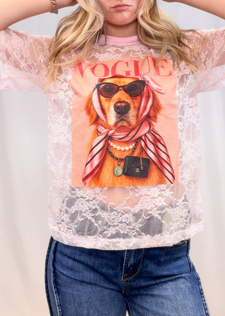 Woman wearing pink lace tee with golden retriever graphic on front with denim jeans on plain background