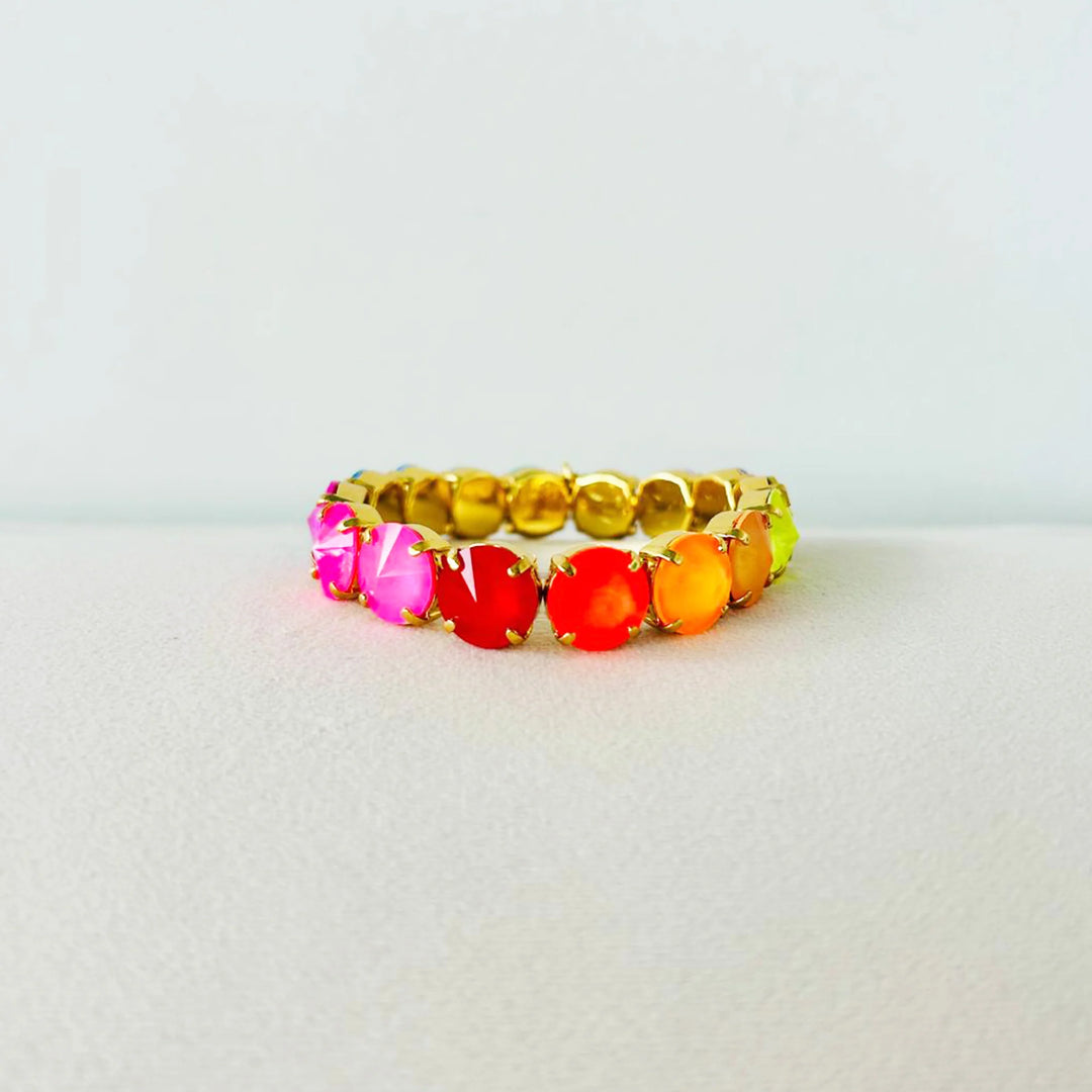 multicolor gemstone and gold bracelet on white background