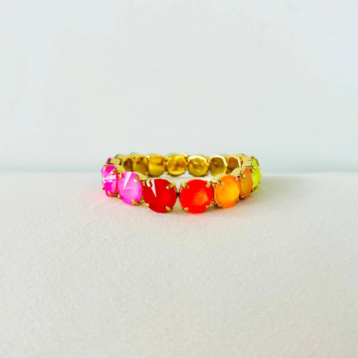 multicolor gemstone and gold bracelet on white background