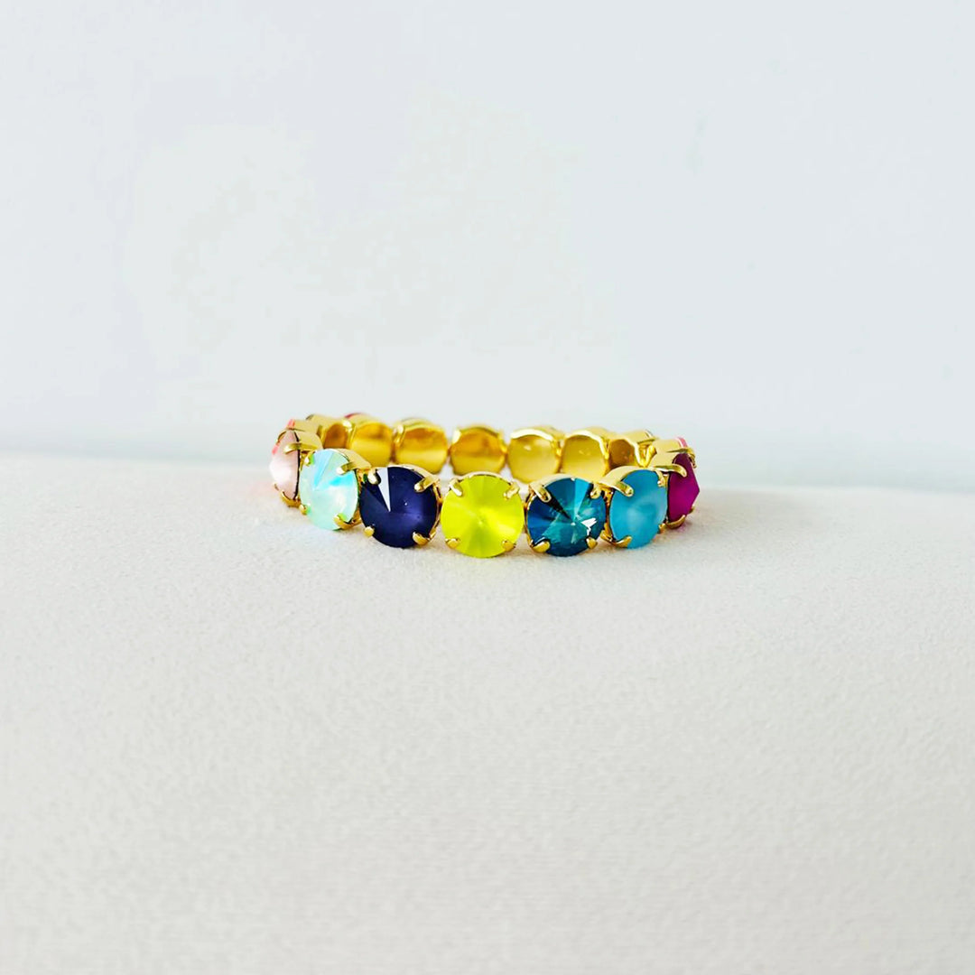 multicolor gemstone and gold bracelet on white background