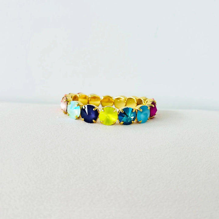 multicolor gemstone and gold bracelet on white background