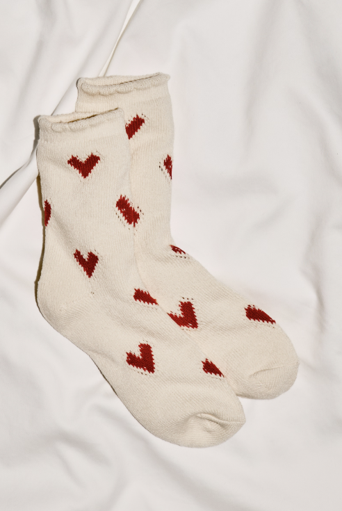 White socks with red hears on plain background