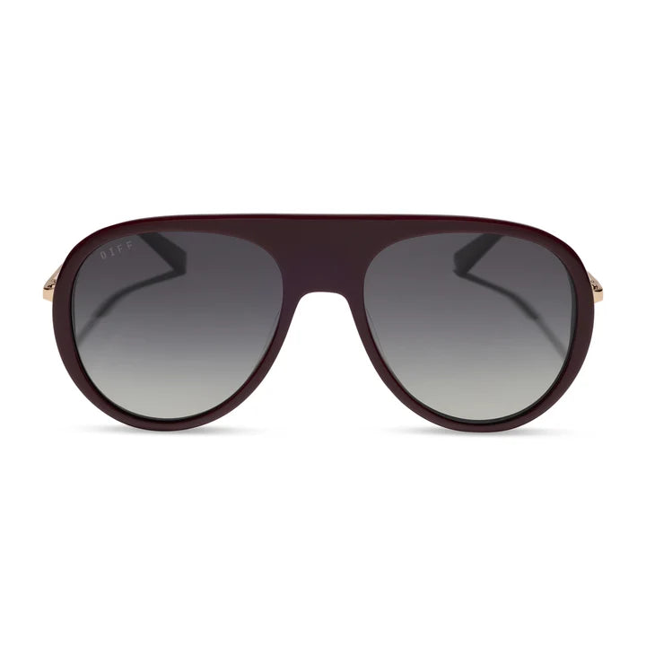 A pair of aviator-style sunglasses with a dark burgundy frame and gradient gray lenses, featuring small gold metal tips on the temples.