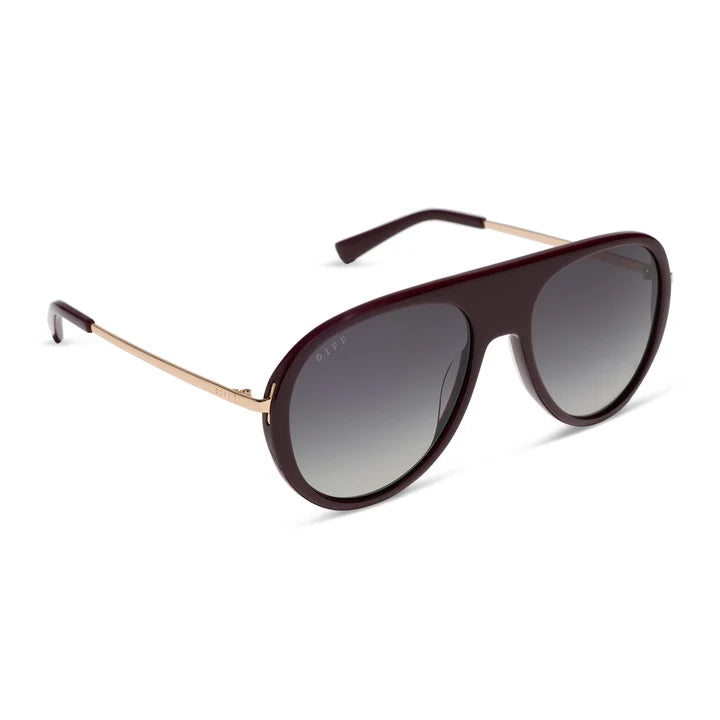 Sunglasses with dark gradient lenses and gold frame on a white background