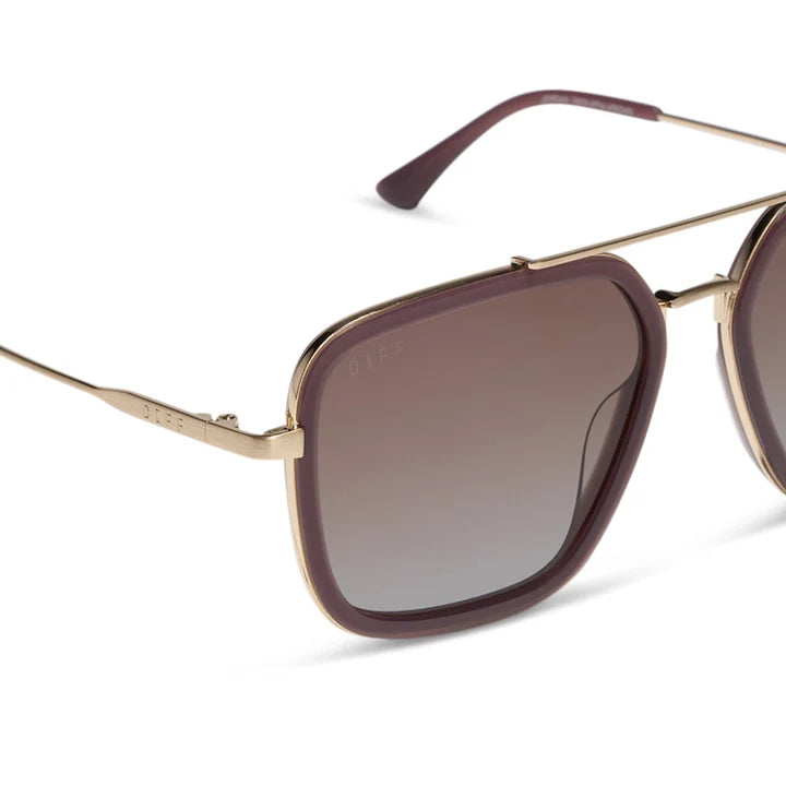 Sunglasses with gold frame and brown gradient lenses on a white background