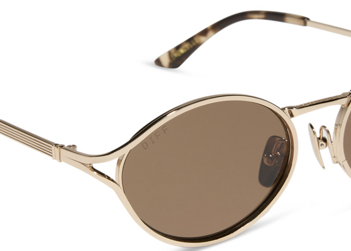 Pair of gold sunglasses with brown lenses on white background