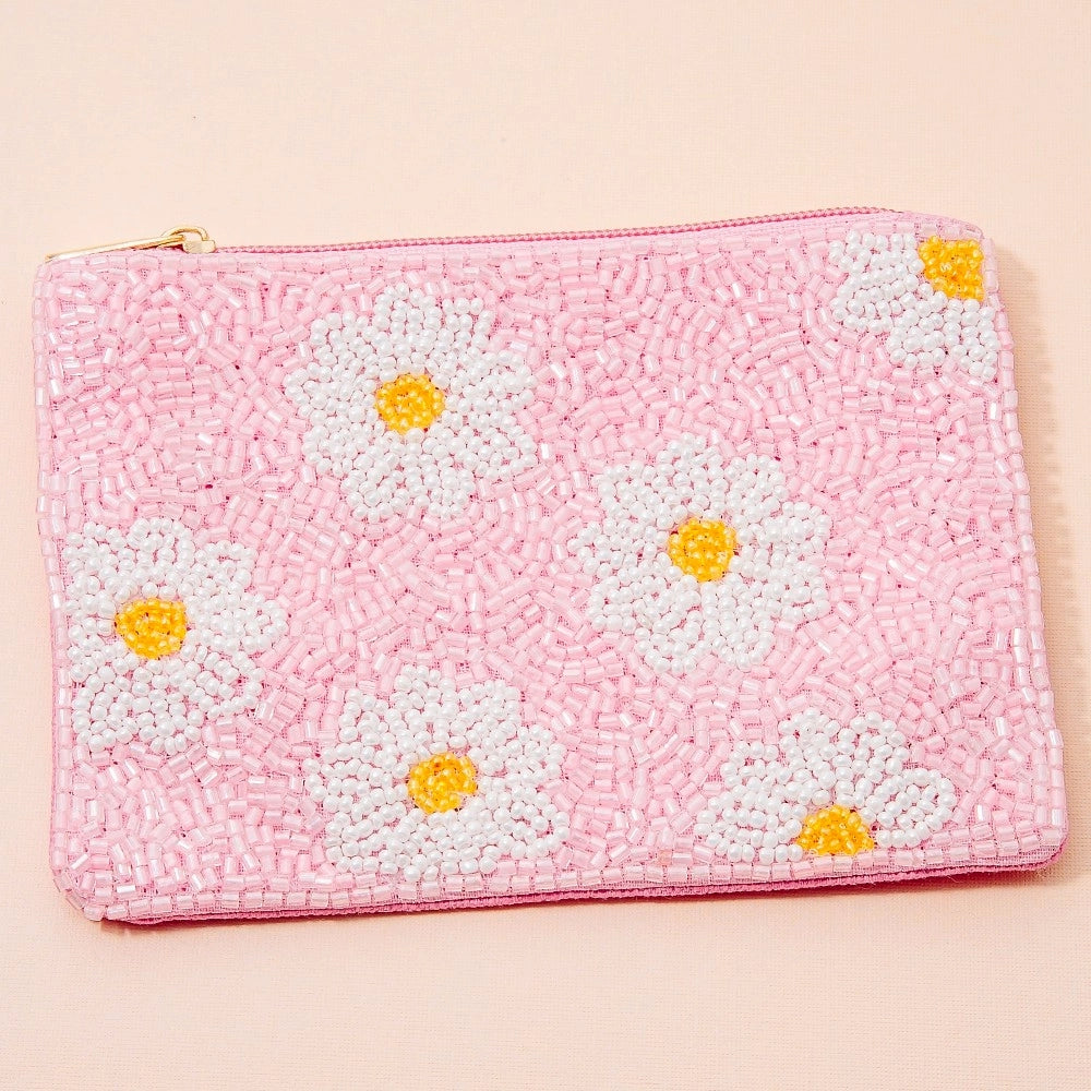 Pink pouch with white daisy patterns on a beige background