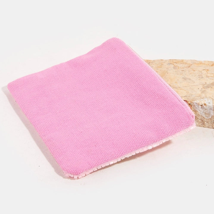 Pink coin purse on a light surface with a neutral background
