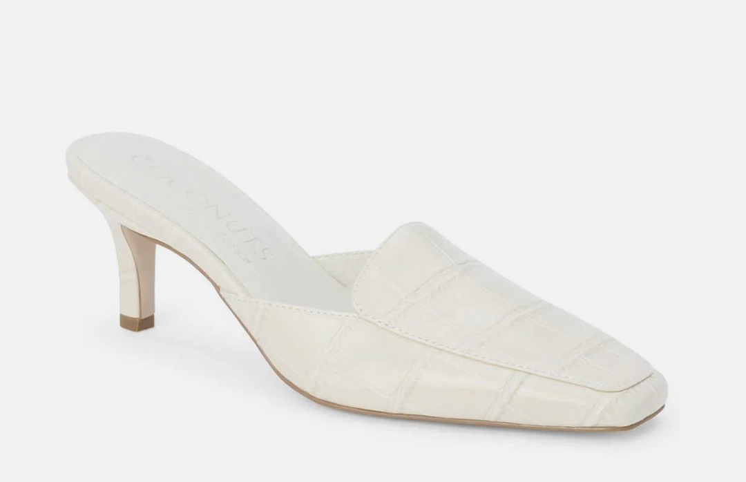 Ivory heeled mule shoe with crocodile embossing on white background