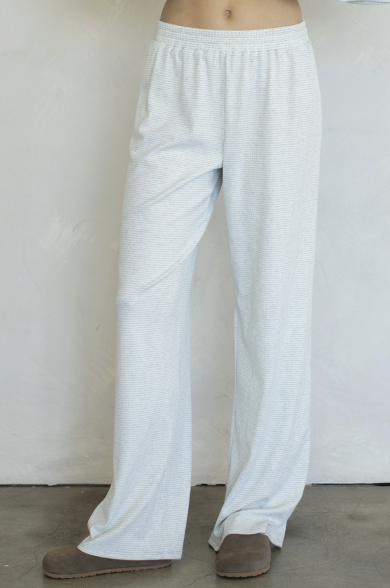 Woman wearing blue stripe pants on plain background