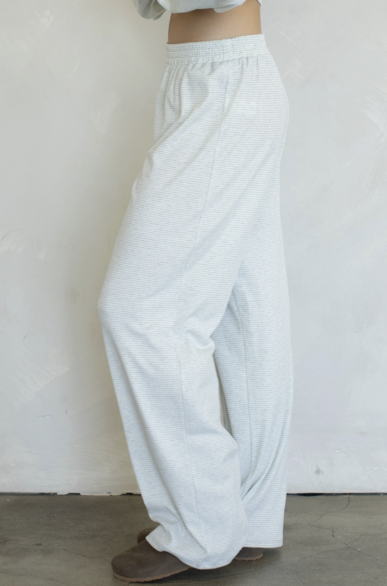 Woman wearing blue stripe pants on plain background