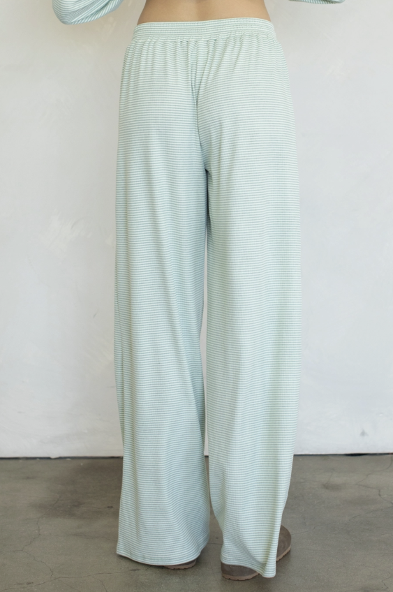 Woman wearing mint stripe pants on plain background
