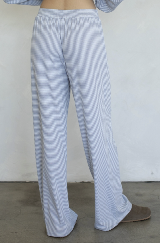 Woman wearing blue stripe pants on plain background