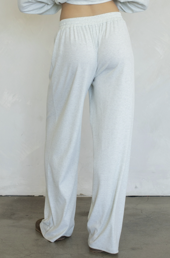 Woman wearing blue stripe pants on plain background