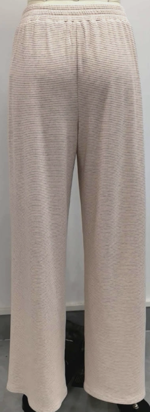 Woman wearing pink stripe pants on plain background