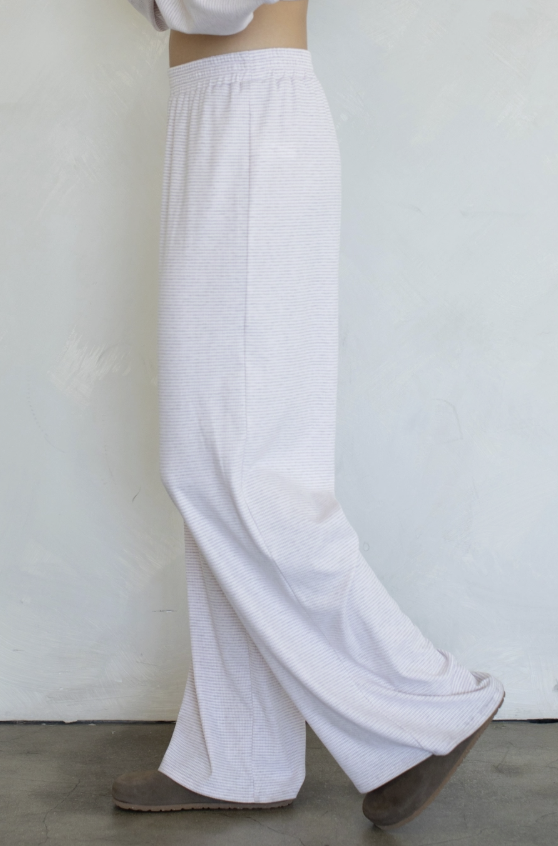 Woman wearing purple stripe pants on plain background