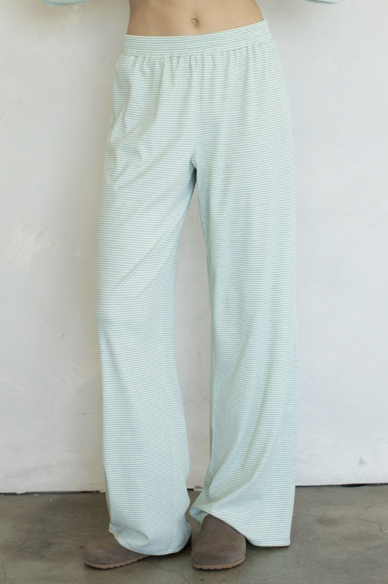 Woman wearing mind stripe pants on plain background