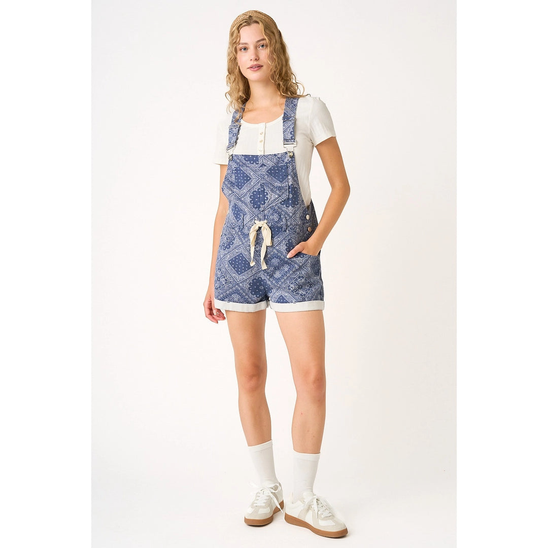 Woman wearing blue patterned overalls on a white background