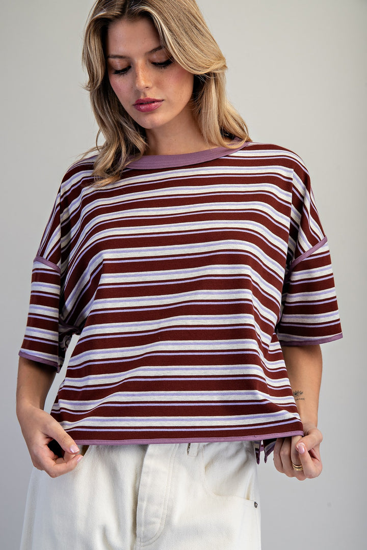 Woman wearing purple stripe tee on plain background